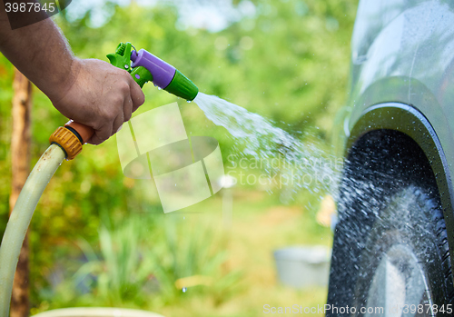 Image of People cleaning car using high pressure water