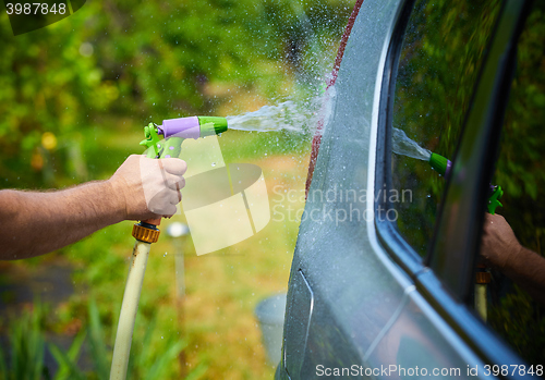 Image of People cleaning car using high pressure water