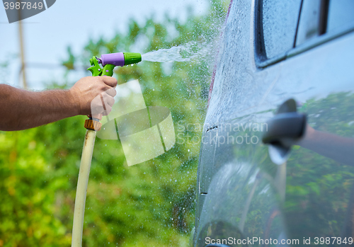 Image of People cleaning car using high pressure water