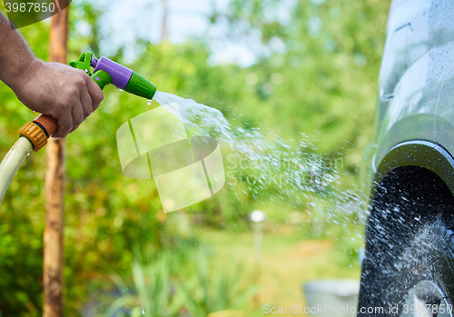 Image of People cleaning car using high pressure water