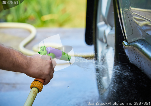 Image of People cleaning car using high pressure water