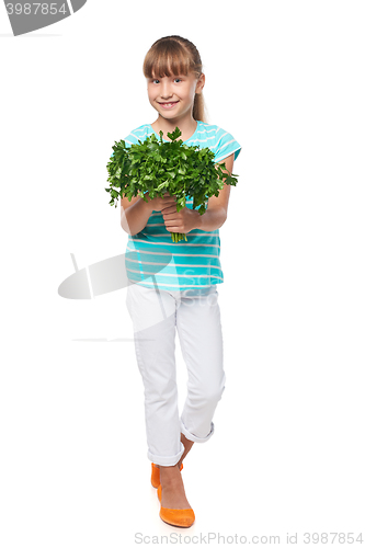 Image of Smiling elementary school age girl showing fresh parsley