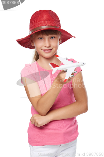 Image of Lovely little girl wearing tourist hat holding small airplane toy