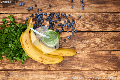 Image of Mug with green smoothie drink and bundle of fresh parsley