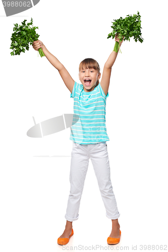 Image of Smiling little girl showing fresh parsley screaming of joy