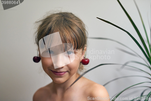 Image of Little girl with a cherry on her ears