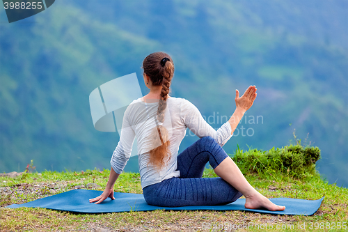Image of Woman practices yoga asana outdoors