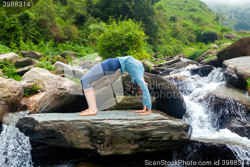 Image of Woman doing Ashtanga Vinyasa Yoga asana Urdhva Dhanurasana  - up