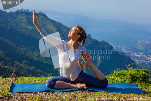 Image of Sorty fit woman doing yoga asana outdoors in mountains