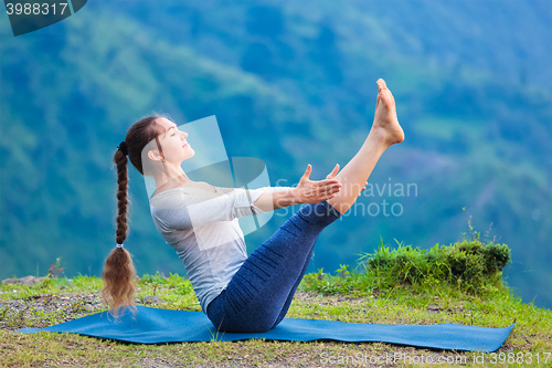 Image of Woman doing Ashtanga Vinyasa Yoga asana Navasana - boat pose