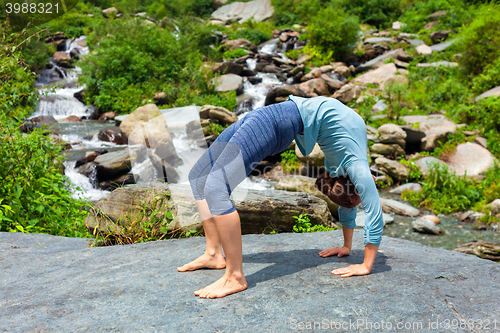 Image of Woman doing Ashtanga Vinyasa Yoga asana Urdhva Dhanurasana  - up