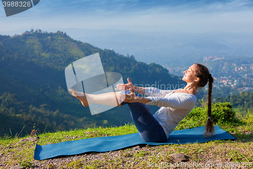 Image of Woman doing Ashtanga Vinyasa Yoga asana Navasana - boat pose