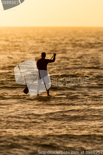 Image of Man paddleboarding