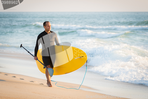 Image of man with his paddle board