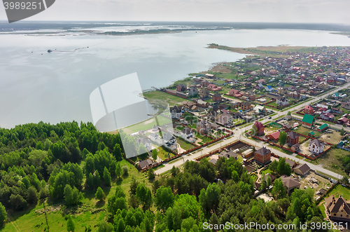 Image of Beautiful small green village near lake and forest