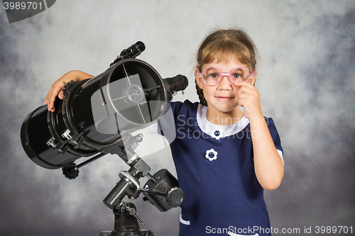 Image of Girl astronomer happily surprised by what he saw in the telescope