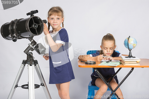 Image of Girl watches in the telescope, the other girl is waiting for the results of observations