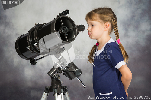 Image of Girl disappointed by what he saw in the telescope