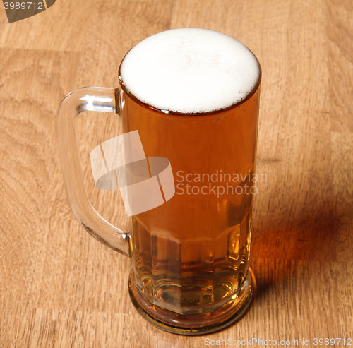 Image of Single beer glass on wooden table