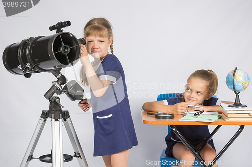 Image of The girl was upset he did not see in the telescope, the other girl mocking her