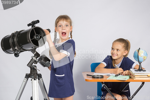 Image of Girl surprised astronomer observing through a telescope, the other girl looked at her