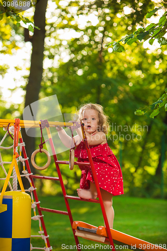 Image of The little baby girl playing at outdoor playground