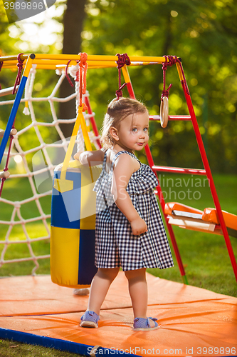 Image of The little baby girl playing at outdoor playground