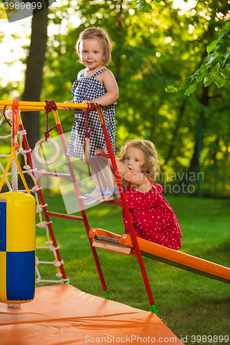 Image of The two little baby girls playing at outdoor playground