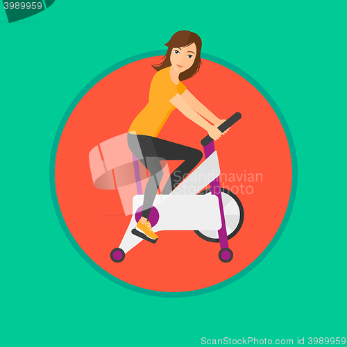 Image of Woman riding stationary bicycle.