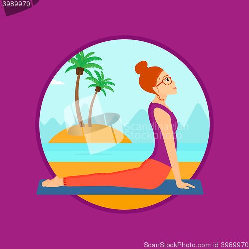 Image of Woman practicing yoga upward dog pose on beach.