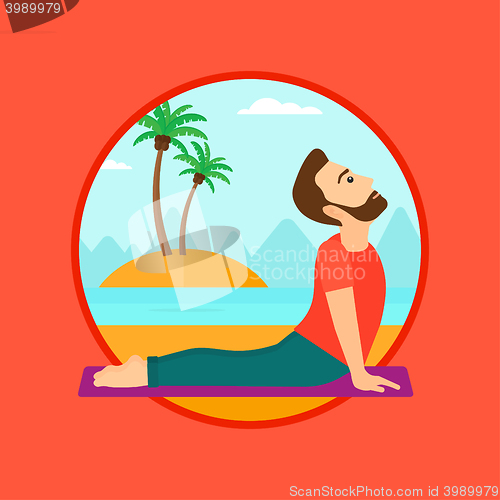 Image of Man practicing yoga upward dog pose on the beach.