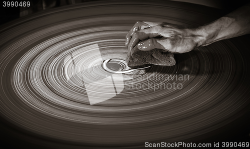 Image of Man\'s hand on a potter\'s wheel