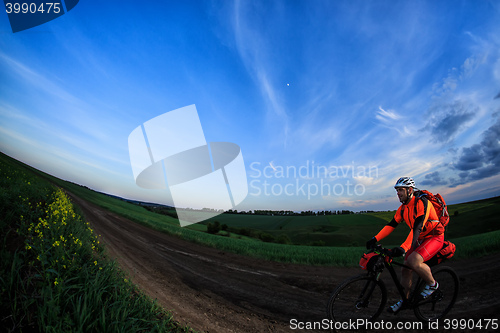 Image of Mountain bikeer rides on the trail against beautiful sunset