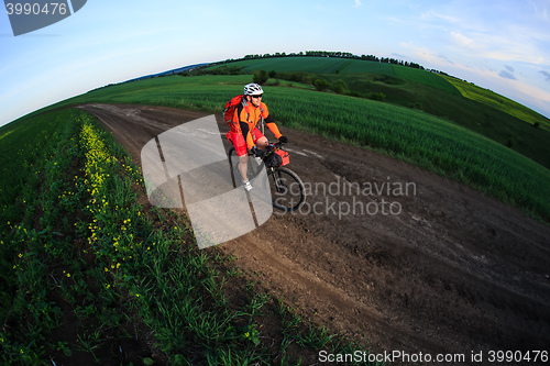 Image of Mountain bikeer rides on the trail against beautiful sunset