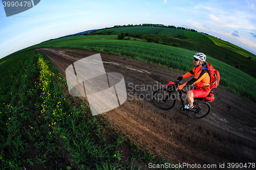 Image of Mountain bikeer rides on the trail against beautiful sunset