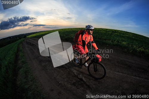 Image of Mountain bikeer rides on the trail against beautiful sunset