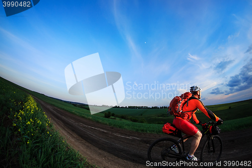 Image of Mountain bikeer rides on the trail against beautiful sunset