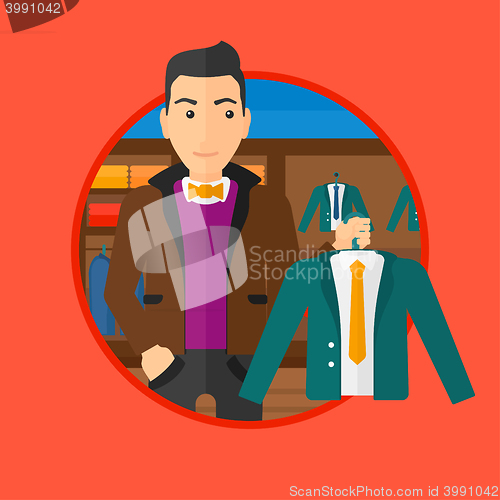 Image of Man holding suit jacket in clothing store.