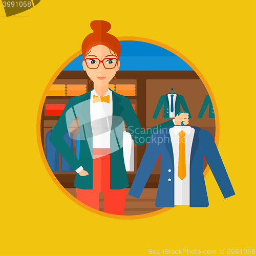 Image of Woman holding jacket in clothing store.