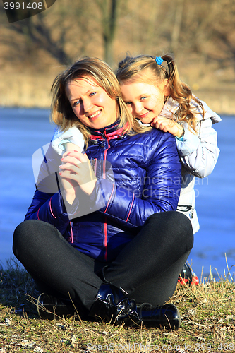 Image of mother and her daughter embrace and smile