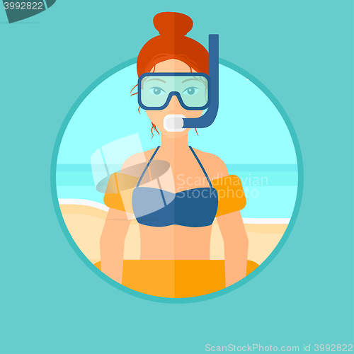 Image of Woman with snorkeling equipment on the beach.