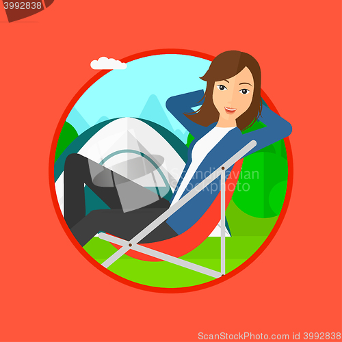 Image of Woman sitting in folding chair in the camp.