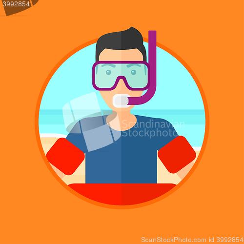 Image of Man with snorkeling equipment on the beach.