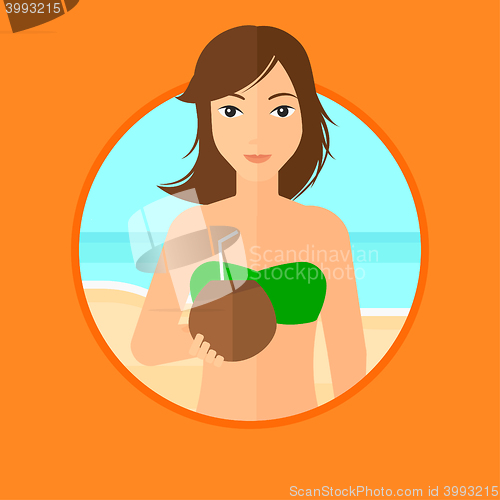 Image of Woman drinking coconut cocktail on the beach.