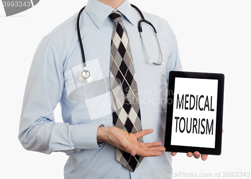 Image of Doctor holding tablet - Medical tourism