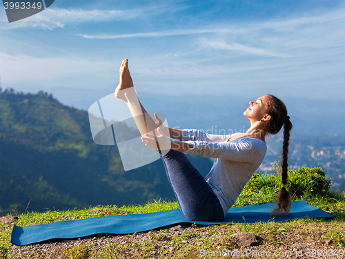 Image of Woman doing Ashtanga Vinyasa Yoga asana Navasana - boat pose