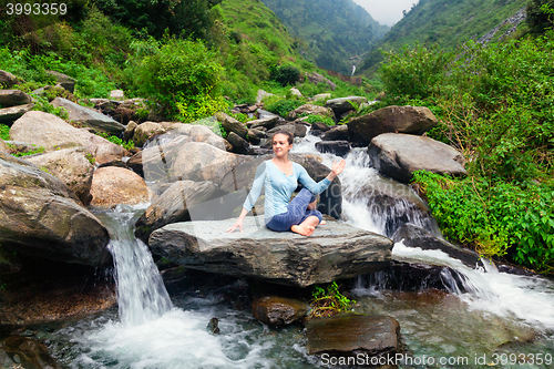 Image of Woman doing Ardha matsyendrasana asana outdoors