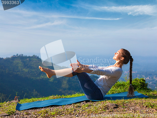 Image of Woman doing Ashtanga Vinyasa Yoga asana Navasana - boat pose