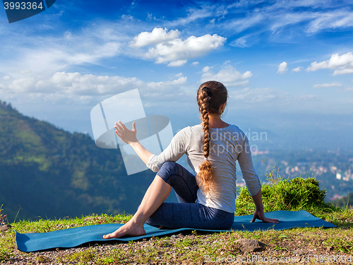 Image of Woman practices yoga asana outdoors