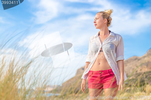 Image of Relaxed woman in white shirt enjoying in nature.